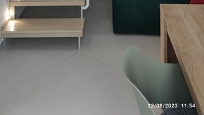 A modern staircase with integrated lighting, a green sofa, and a wooden table in a minimalist living space. - Originale, Elegante e Confortevole Location nei Pressi Della Città Antica (Pompei)
