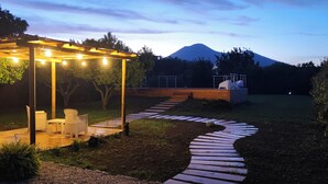 An outdoor patio area with a pergola, seating, and a winding pathway leading to a wooden deck. - Originale, Elegante e Confortevole Location nei Pressi Della Città Antica (Pompei)
