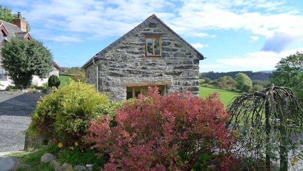 A stone cottage with a pitched roof, a small window, and a door. - Ty Beic Country Apartments, The Barn (Sarnau Bala)