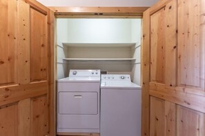 A laundry room with wooden cabinets and a washing machine. - Stunning Treasury Point condo, 3BD/3BA+Hot Tub! (Mt. Crested Butte)