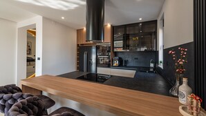 Een moderne keuken met een centraal eiland, inbouwapparatuur en een strak design.
