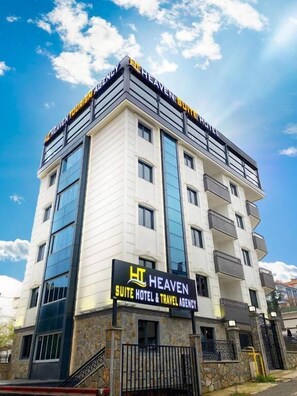 Un hotel de varios pisos con un letrero que dice "Heaven Suite Hotel & Travel Agency".
