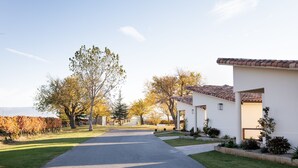 A residential street with houses, a clear sky, and a vineyard in the background. - Villas Finca La Emperatriz (Baños de Rioja)