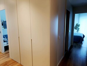 A bedroom with a bed, a window with blinds, and a plant. - Cavalos de Ofir (Fão)