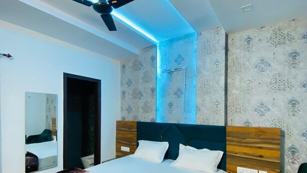 Un dormitorio moderno con una cama grande, un ventilador de techo y papel tapiz estampado.