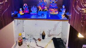 Un santuario con múltiples estatuas de deidades, un altar de mármol y un teléfono.