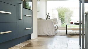 A modern kitchen with dark cabinets and a tiled floor.