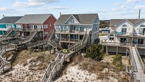 Een strandhuisje aan het strand, met verschillende houten steigers die naar strandhuizen leiden.