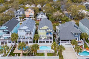 A residential area with multiple two-story houses, each featuring a front deck and a swimming pool. - Walk to the Beach 6 BR Beach House with a Private Pool! 4 Family Fun  (Surfside Beach)