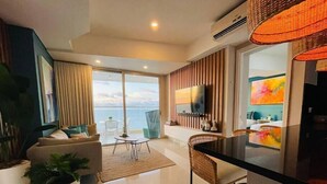A modern living room with a sofa, a dining table, and a kitchen area with a TV. - SPECTACULAR Jewel @ Palmetto Eliptic Bocagrande 34th Floor (Cartagena de Indias)