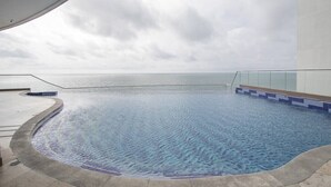 A swimming pool with a view of the sea, surrounded by a modern building. - SPECTACULAR Jewel @ Palmetto Eliptic Bocagrande 34th Floor (Cartagena de Indias)