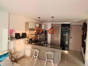 A modern kitchen with a central island, two bar stools, pendant lights, and a chalkboard sign. - SPECTACULAR Jewel @ Palmetto Beach Bocagrande 32th Floor (Cartagena de Indias)