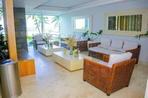 A modern living room with wicker furniture, a white sofa, and a coffee table. - SPECTACULAR Jewel @ Palmetto Beach Bocagrande 32th Floor (Cartagena de Indias)