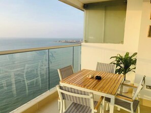 A balcony with a wooden table and chairs, a potted plant, and a view of the sea. - SPECTACULAR Jewel @ Palmetto Beach Bocagrande 32th Floor (Cartagena de Indias)