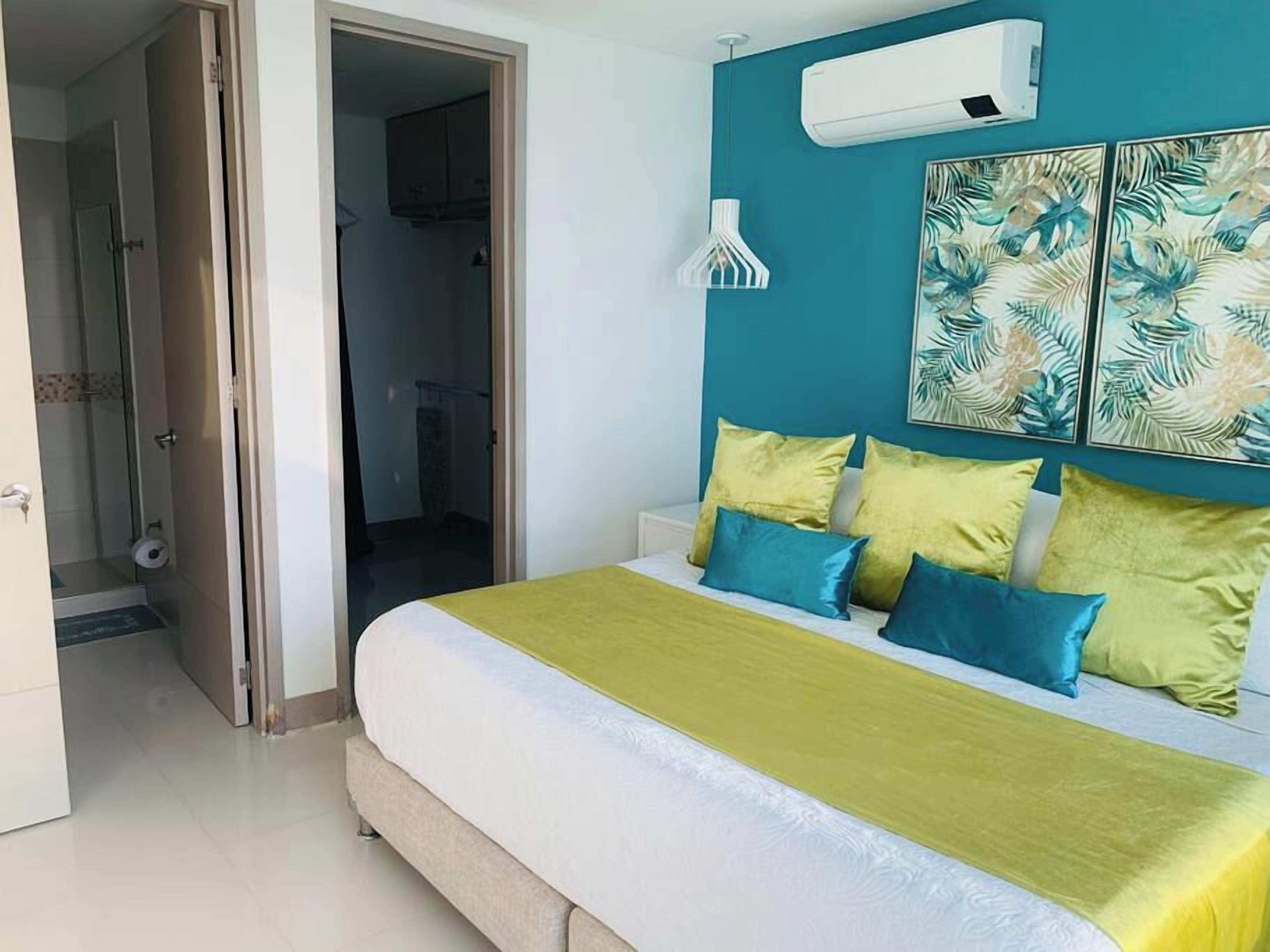 A bedroom with a bed, a door, and a wall-mounted air conditioner.