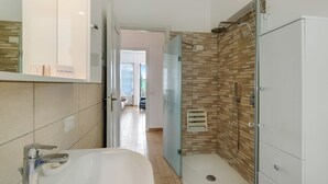 A modern bathroom with a glass shower enclosure, a white sink, and a mirrored cabinet. - Il Giardino Di Dante Stresa Center: 2BR Terrace Apartment (Stresa)