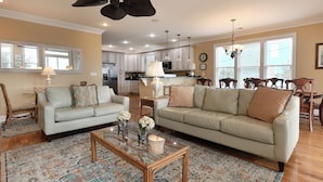 A spacious living room with two sofas, a coffee table, and a patterned rug.
