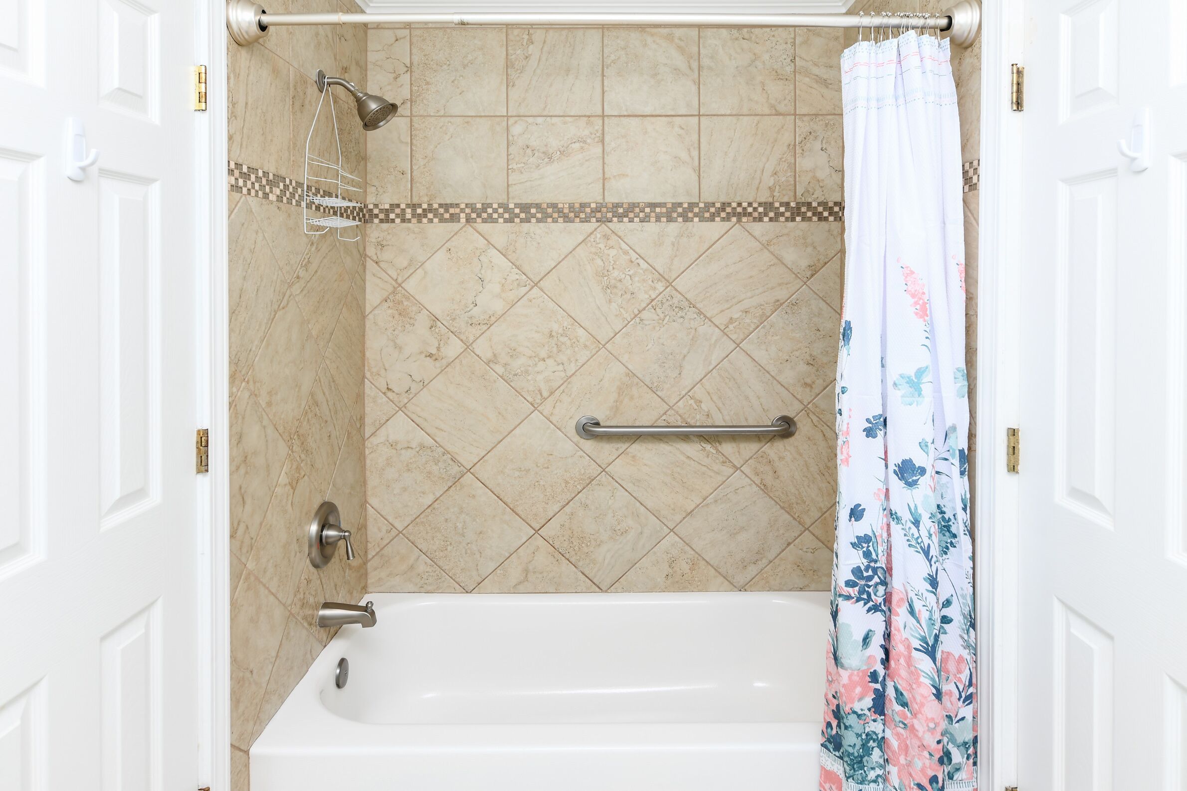 Une salle de bain équipée d’une baignoire, d’une douche et d’un porte-serviettes.