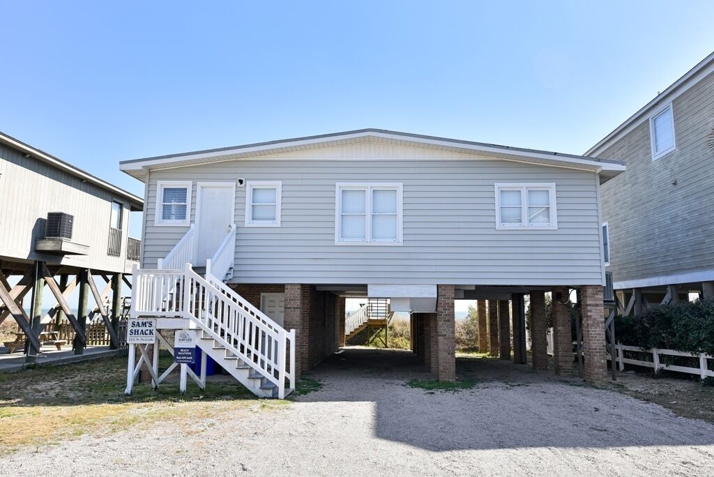 A two-story house with a covered porch and a staircase leading to the upper level.