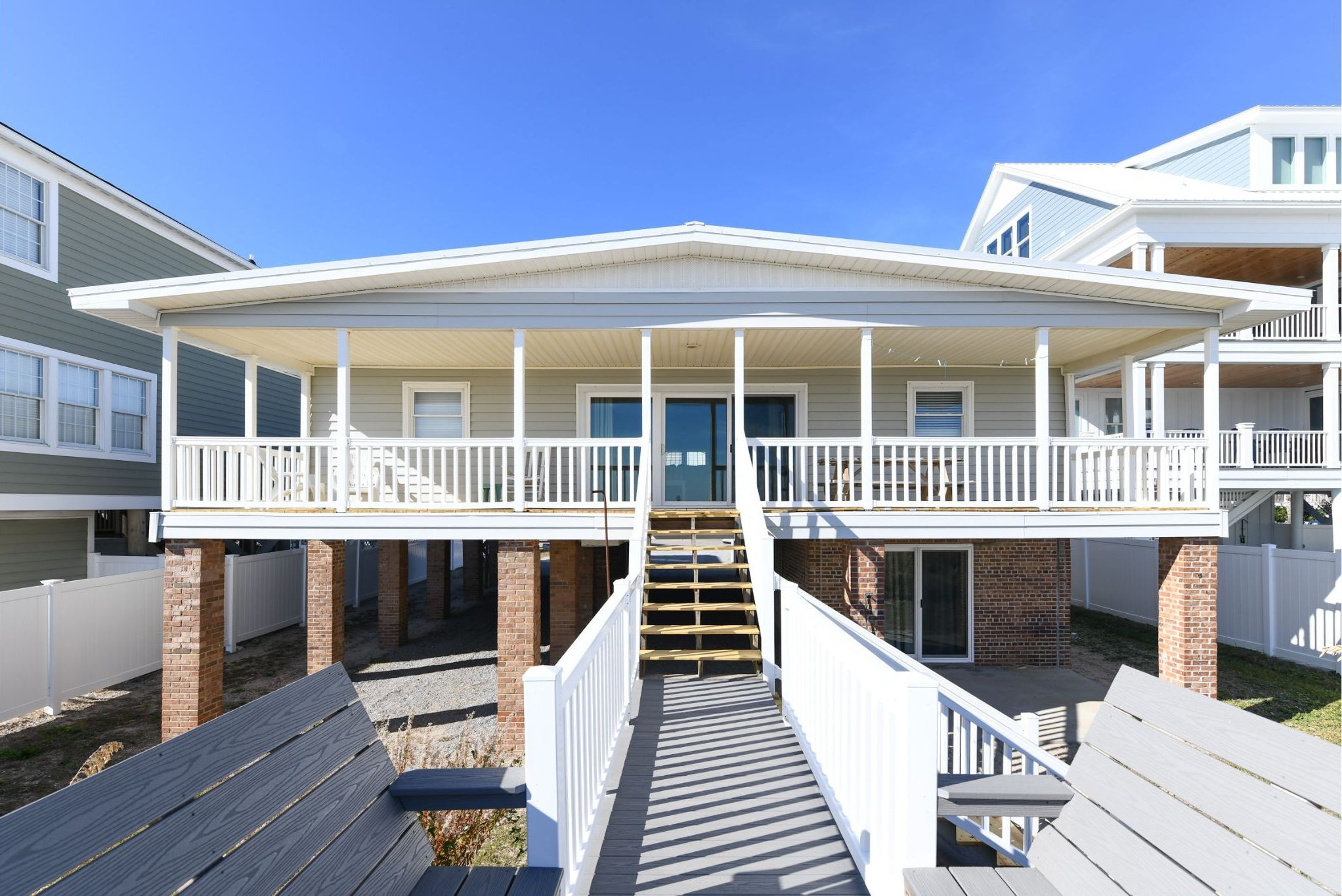 A two-story building with a covered front porch and a staircase leading to the entrance.