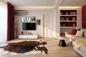 A modern living room with a flat-screen TV, a bookshelf, a sofa, and a cowhide rug. - Qult • Old City Pearl (București)