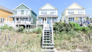 A row of beach houses with multiple decks and a wooden staircase leading to the beach. - Oceanfront 4 BR Beach House with a Private Pool! Surfin' Turf (Surfside Beach)