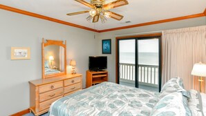 A bedroom with a bed, a dresser, a television, a ceiling fan, and a view of the ocean through a sliding door. - Oceanfront 3 BR Condo with a Shared Pool! Surfwatch III 401  (Surfside Beach)