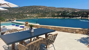 Eine Terrasse mit Tisch und Stühlen mit Blick auf die Küste.