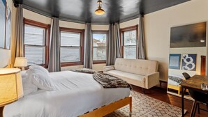 Ein Schlafzimmer mit Bett, Sofa, Tisch und Lampe.