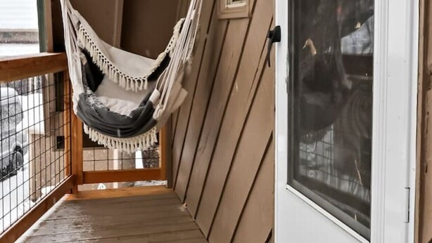 A wooden deck with a hammock chair and a white door. - Cozy Hideaway Retreat Unit 4 near Durango, CO. (Durango)