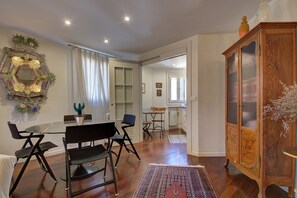 A dining area with a glass table, black chairs, and a wooden cabinet.