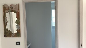 A hallway with a white door leading to a bathroom. - Animaux Interdits Parking Privé Proche de la mer vue mer (Santa Lucia di moriani)