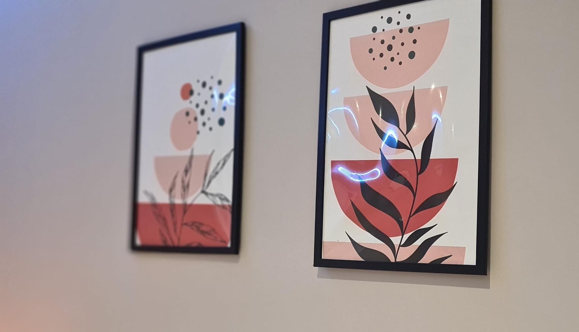 Deux œuvres d’art encadrées sont accrochées au mur.
