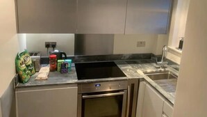 A modern kitchen with stainless steel appliances, a built-in oven, and a sink.
