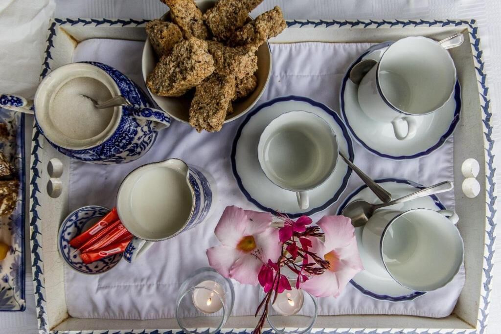 A tray with food items, cups, and a candle.