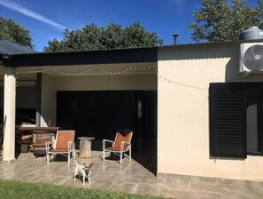 Relax in style with a patio featuring a table and two chairs, surrounded by lush greenery and a cozy ambiance.