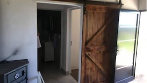 Une pièce dotée d’une porte coulissante de style grange, d’un coin cuisine et offrant une vue sur l’extérieur.