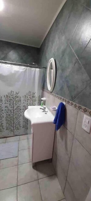 Bathroom features a pedestal sink and mirror, with a towel hung on the wall.