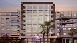 A modern hotel with a prominent 'Courtyard by Marriott' sign, featuring a multi-story structure with balconies and large windows. - Courtyard by Marriott Casablanca Downtown (Casablanca)