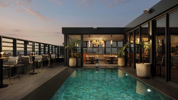 A rooftop pool area with seating and a dining area, surrounded by glass walls and potted plants. - Courtyard by Marriott Casablanca Downtown (Casablanca)