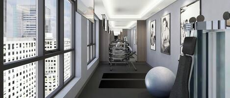 Un couloir d’hôtel moderne, doté de grandes fenêtres, d’équipements de musculation et d’œuvres d’art accrochées aux murs.