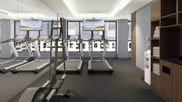 A modern gym with treadmills, a stationary bike, and a TV screen displaying a beach view.