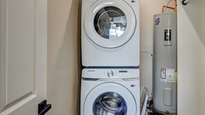 A stacked washer and dryer unit with a water heater to the right. - Beautiful dog friendly apartment! STR-243 (Buena Vista)