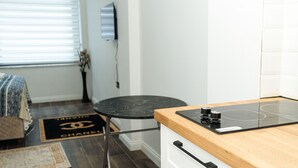Una cocina moderna con encimera de madera, estufa negra y una mesa redonda negra.
