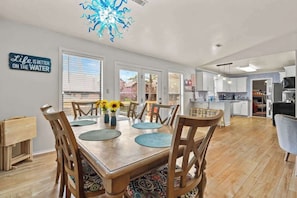 A dining area with a wooden table, chairs, and a decorative ceiling light.