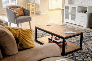 A living room with a sofa, a coffee table, a cabinet, and a patterned rug.