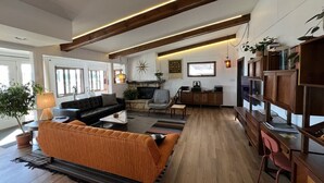 Una sala de estar amplia con sofá, chimenea y estantería.
