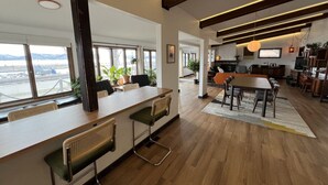 A spacious, modern kitchen with wooden flooring, a large island with bar stools, and a dining area with a table and chairs. - Pepin’s Premier Waterfront Stay — The Dockside (Pepin)