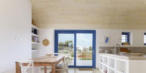 Una cocina moderna con comedor, ventanas amplias y vistas al exterior.