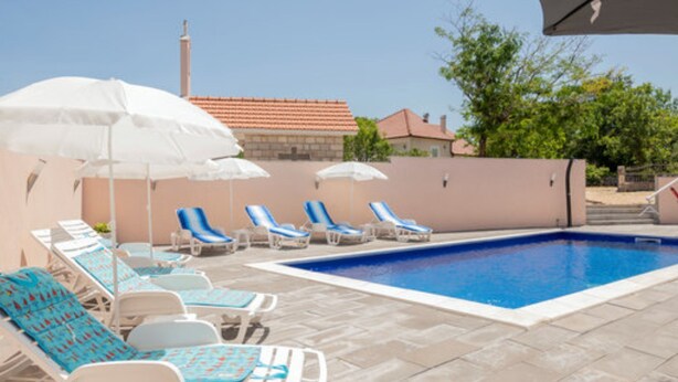 Una piscina al aire libre de temporada, sombrillas
